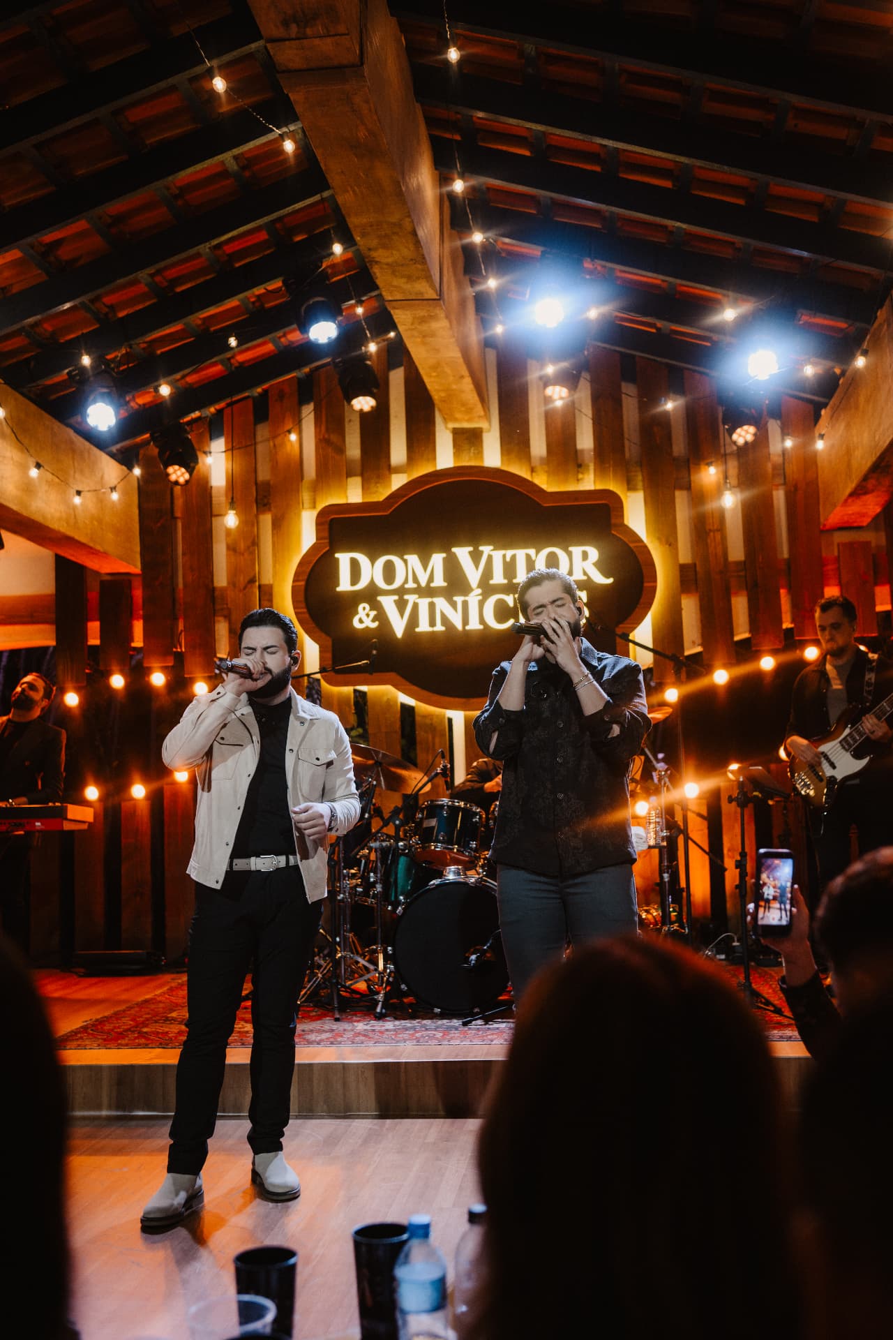 Dom Vitor e Vinícius cantando no palco